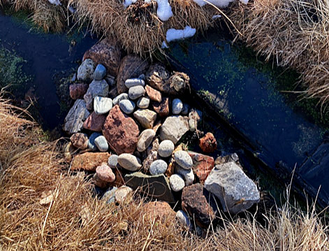 ©S.L.Reay photo of stones in a creek with spots of snow in brown grass